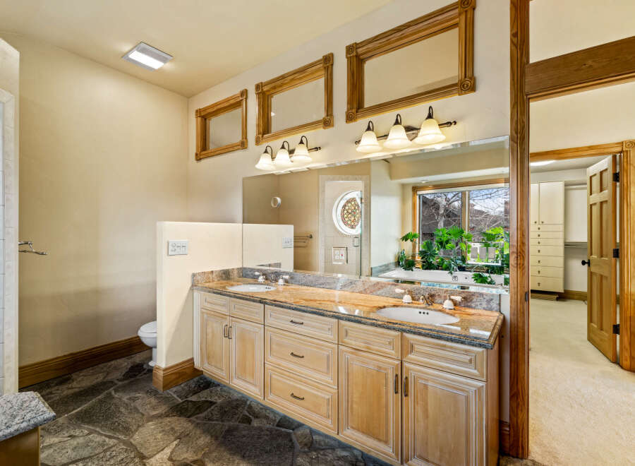 This luxurious bathroom features a stunning granite countertop and custom cabinetry, offering both style and functionality.