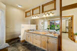 This luxurious bathroom features a stunning granite countertop and custom cabinetry, offering both style and functionality.