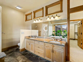 This luxurious bathroom features a stunning granite countertop and custom cabinetry, offering both style and functionality.