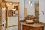 Step into luxury with this stunning bathroom featuring a unique stone countertop and a stylish vessel sink.