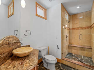 This luxurious bathroom features a stunning granite countertop with a matching sink, creating a cohesive and elegant look.