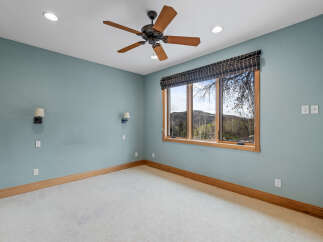 This stunning bedroom boasts a serene ambiance with its soft blue walls and natural light streaming through the large windows.