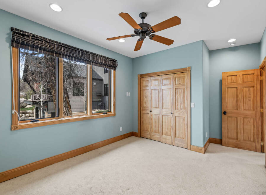 This inviting bedroom features a neutral color palette and ample natural light, creating a serene atmosphere.