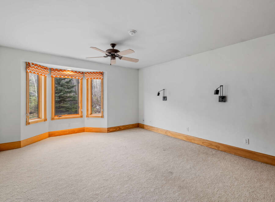 This spacious room features a large bay window, allowing natural light to flood the space.