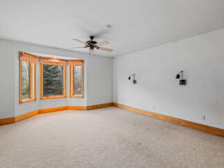 This spacious room features a large bay window, allowing natural light to flood the space.