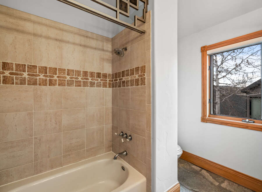 This beautiful bathroom features a tiled shower and tub, perfect for a relaxing soak.
