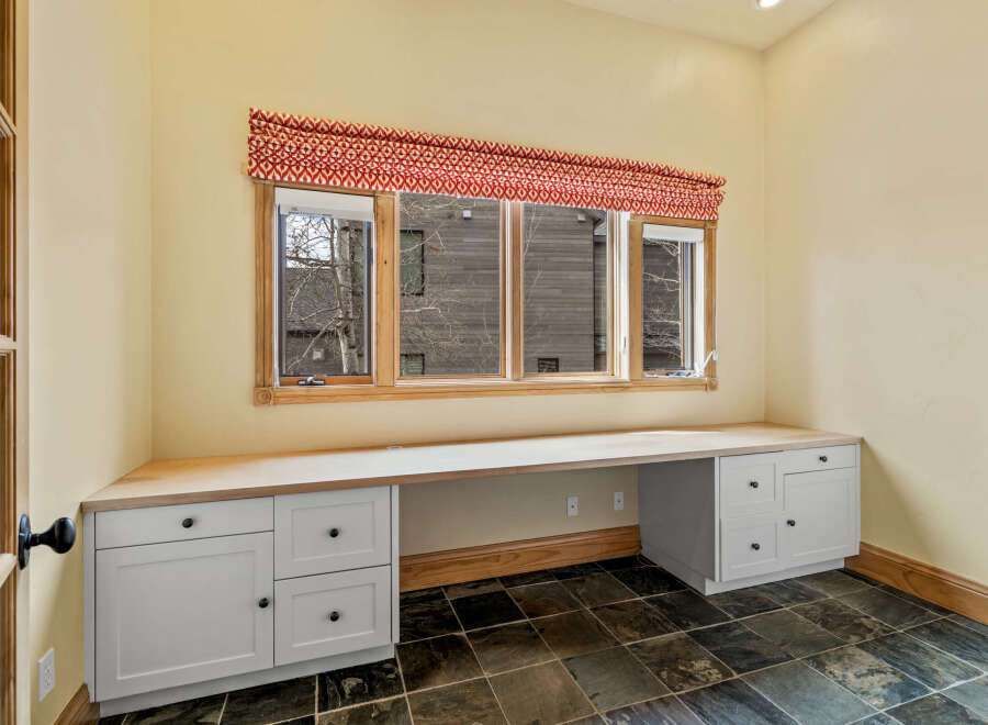 This inviting home office space features a built-in desk with ample storage, perfect for productivity.