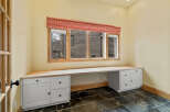 This inviting home office space features a built-in desk with ample storage, perfect for productivity.