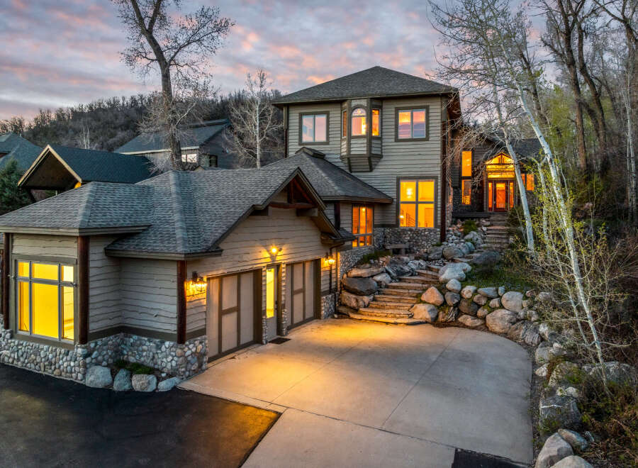 This stunning property boasts a beautiful exterior with a combination of stone and wood siding, creating a warm and inviting atmosphere.