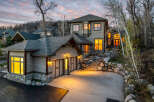 This stunning property boasts a beautiful exterior with a combination of stone and wood siding, creating a warm and inviting atmosphere.