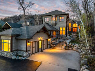 This stunning property boasts a beautiful exterior with a combination of stone and wood siding, creating a warm and inviting atmosphere.