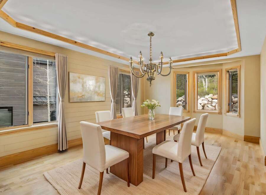 This elegant dining room features a stunning wooden table and stylish white chairs, perfect for hosting memorable gatherings.
