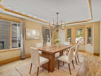 This elegant dining room features a stunning wooden table and stylish white chairs, perfect for hosting memorable gatherings.