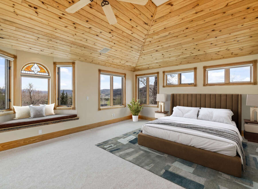 This stunning bedroom boasts a unique architectural design with a vaulted, wood-paneled ceiling that adds warmth and character.