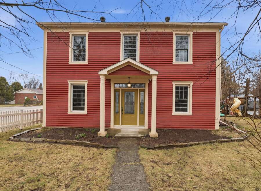 This stunning two-story home boasts a classic red exterior with charming architectural details.