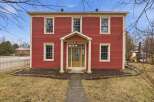 This stunning two-story home boasts a classic red exterior with charming architectural details.
