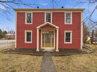This stunning two-story home boasts a classic red exterior with charming architectural details.