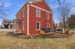 This charming two-story home boasts a vibrant red exterior, creating a striking curb appeal.