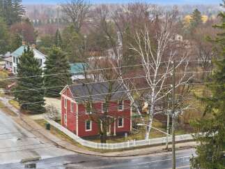 This charming red house, nestled in a serene neighborhood, offers a blend of classic architecture and modern comfort.