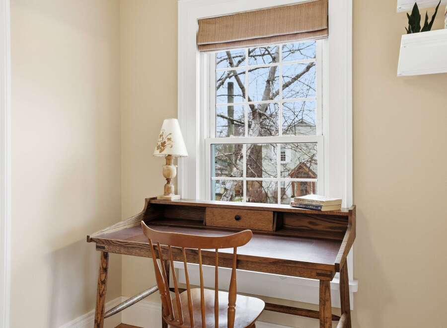 This charming home office features a classic wooden desk and chair, perfect for focused work or creative endeavors.