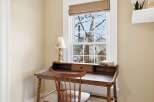 This charming home office features a classic wooden desk and chair, perfect for focused work or creative endeavors.