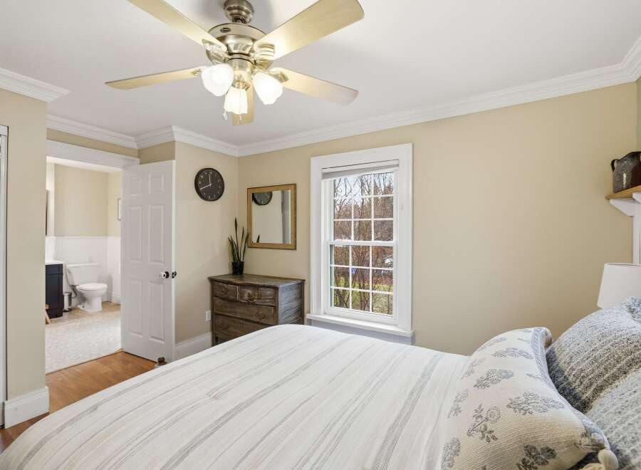 This cozy bedroom features a comfortable bed with stylish pillows and a ceiling fan for added comfort.