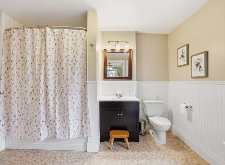 This charming bathroom features a stylish shower curtain with a floral pattern, adding a touch of elegance to the space.