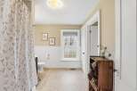 Step into this charming bathroom, featuring a delightful floral shower curtain and a cozy, inviting atmosphere.