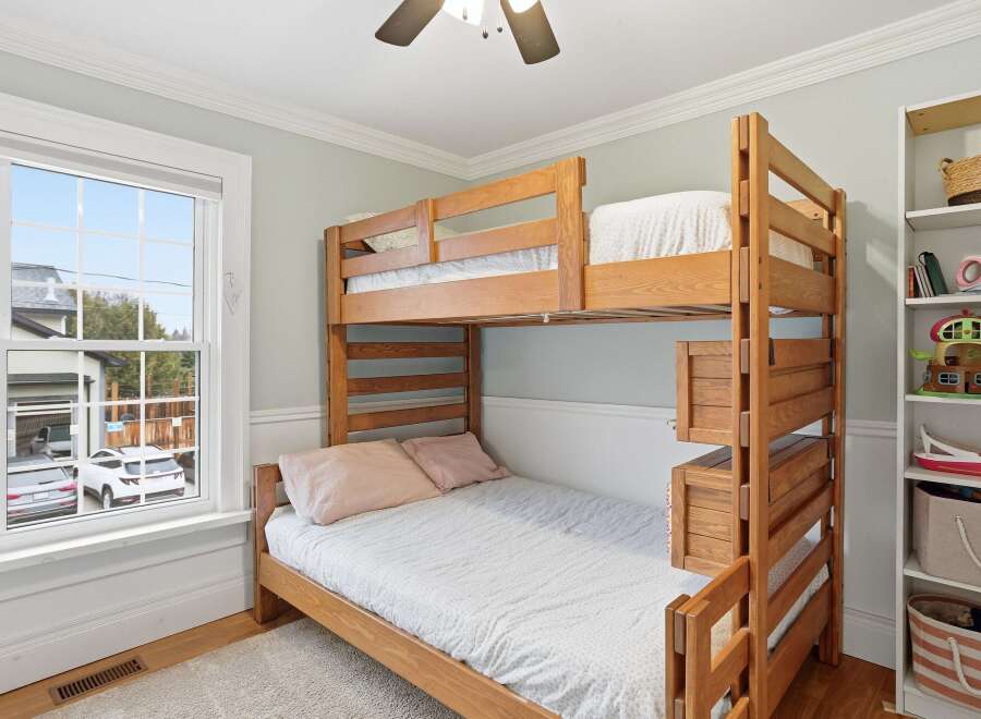 This charming bedroom features a sturdy wooden bunk bed, perfect for kids or guests.