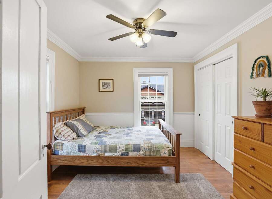This charming bedroom features a cozy wooden bed frame and a colorful quilt, creating a warm and inviting atmosphere.