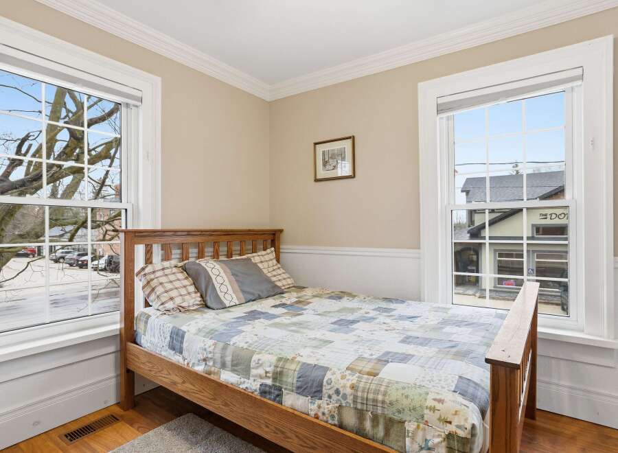 This charming bedroom features a cozy wooden bed frame and a beautifully patterned quilt, creating a warm and inviting atmosphere.