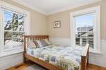This charming bedroom features a cozy wooden bed frame and a beautifully patterned quilt, creating a warm and inviting atmosphere.