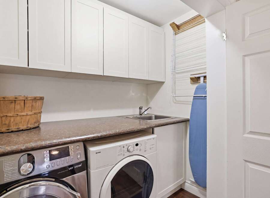 This laundry room features a sleek design with ample storage and modern appliances.