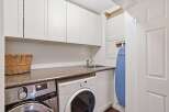 This laundry room features a sleek design with ample storage and modern appliances.