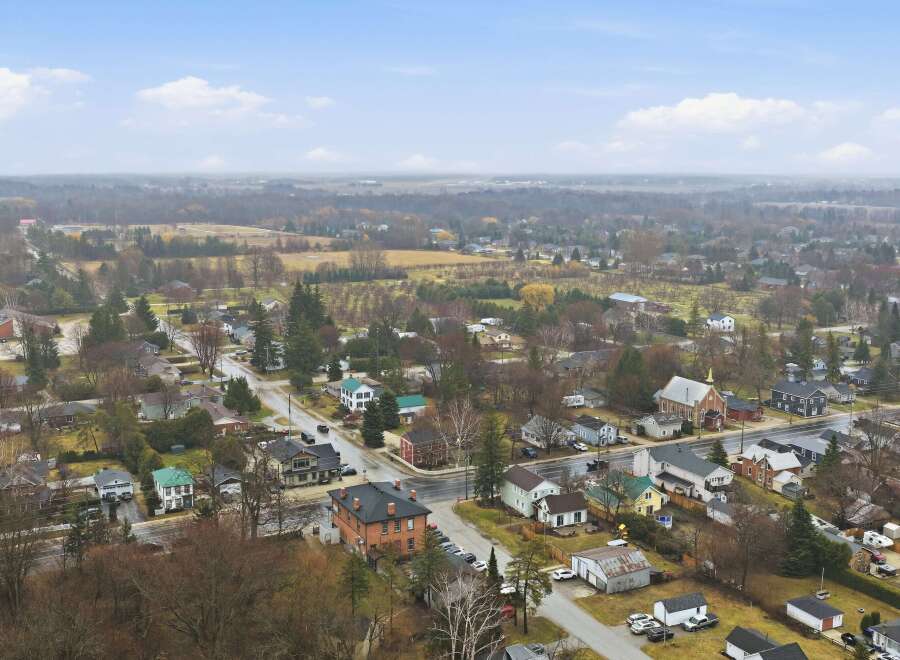 This aerial view showcases a charming townscape, featuring a mix of residential homes and commercial buildings.