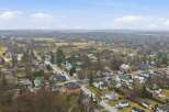 This aerial view showcases a charming townscape, featuring a mix of residential homes and commercial buildings.