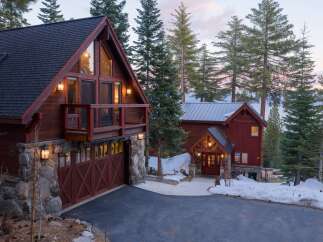 This stunning mountain home boasts a rustic charm with its wooden exterior and stone accents.