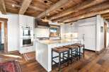 This stunning kitchen boasts a rustic charm with its exposed wooden beams and elegant white cabinetry.