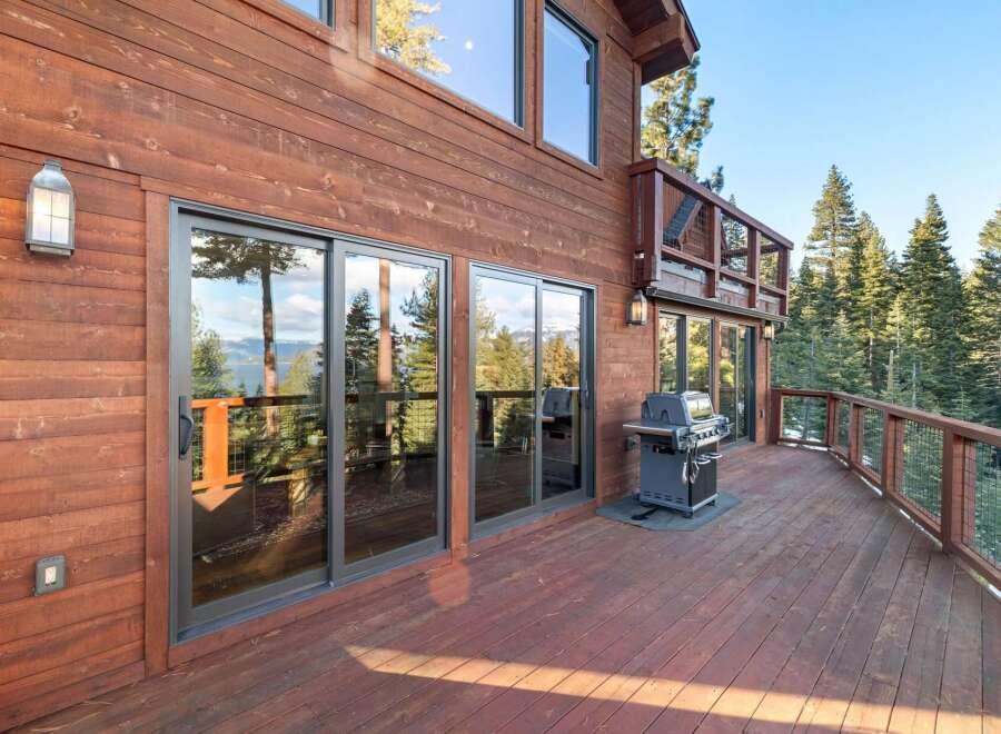 Enjoy breathtaking views from this stunning property featuring a spacious deck and a modern grill, perfect for outdoor entertaining.