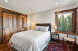This stunning bedroom boasts rustic charm with its wooden barn doors and window trim.