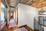 Step into luxury with this stunning hallway featuring a rustic wooden ceiling and elegant hardwood floors.