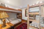 This charming bedroom features rustic bunk beds, perfect for accommodating guests or family.