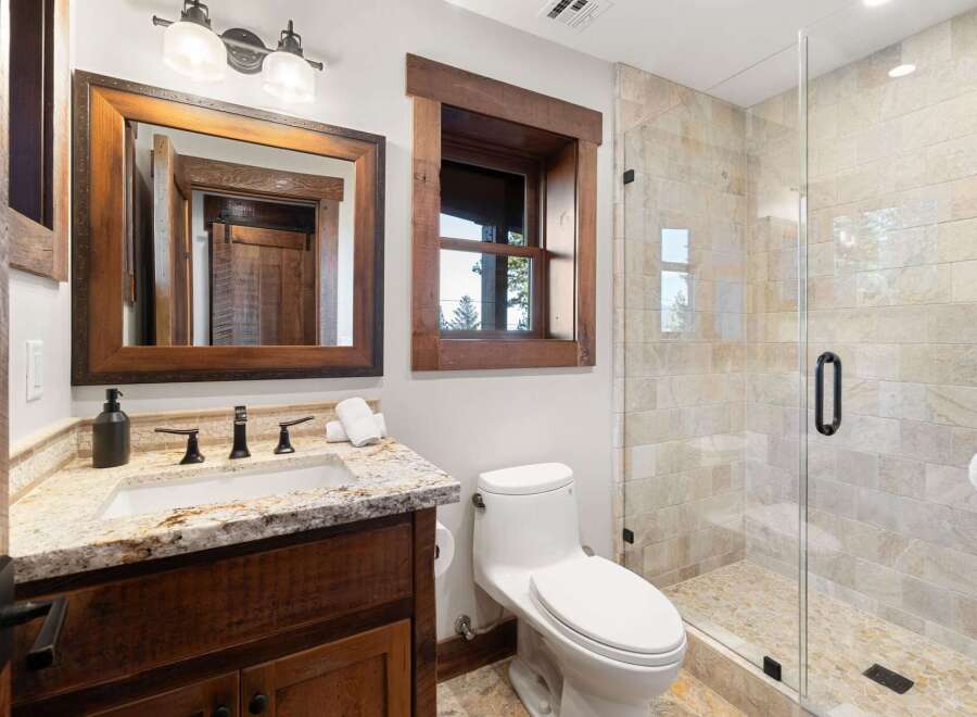 This stunning bathroom boasts a rustic charm with its wooden accents and elegant design.