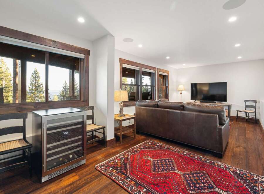 Experience luxury living in this stunning property featuring a spacious living area with a cozy leather sofa and a large flat-screen TV.