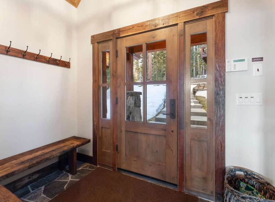 Step into luxury with this stunning entryway featuring a beautiful wooden door and sidelights.