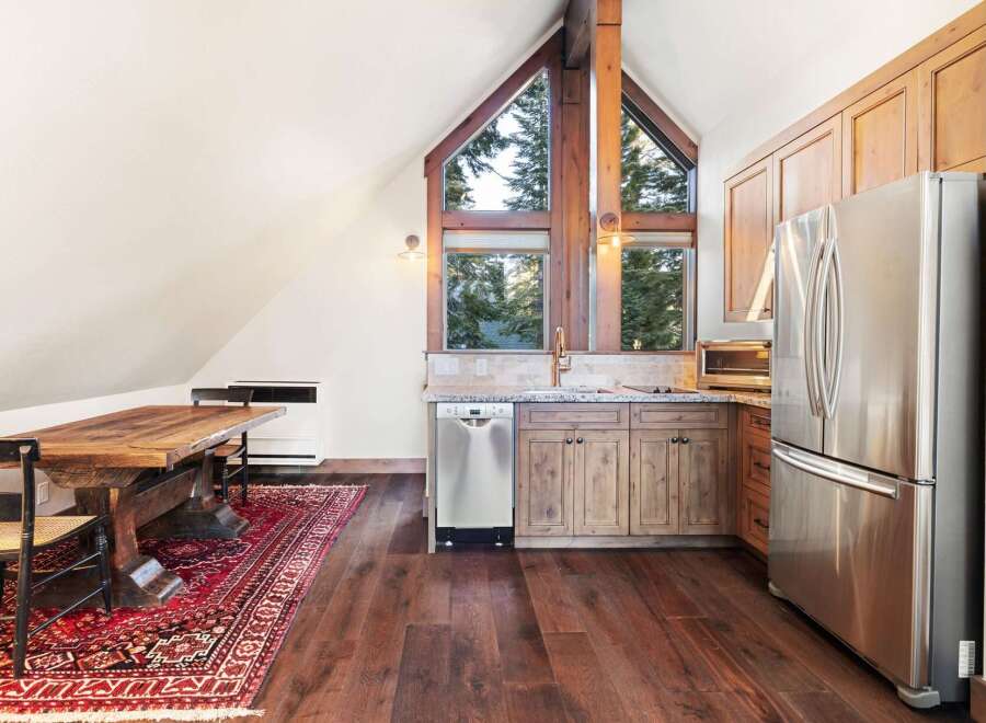 This stunning kitchen features a unique architectural design with a vaulted ceiling and a large window that offers breathtaking views.