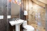 This stunning bathroom boasts a rustic charm with its reclaimed wood walls and modern fixtures.