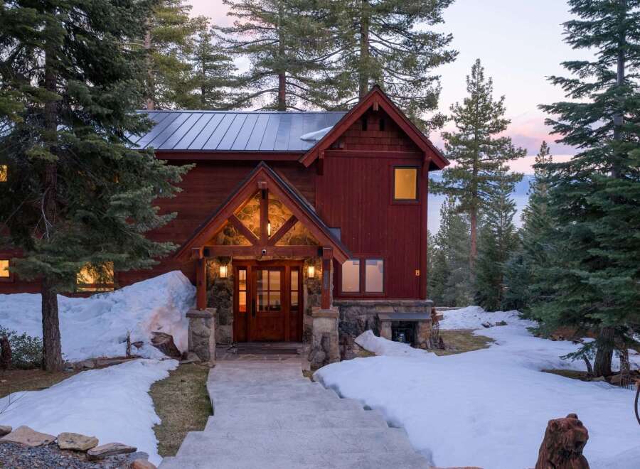 This stunning mountain home boasts a rustic charm with its wooden exterior and stone accents.