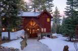 This stunning mountain home boasts a rustic charm with its wooden exterior and stone accents.