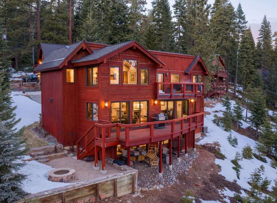 Nestled amidst a serene forest, this stunning property boasts a striking red exterior and a multi-level design.